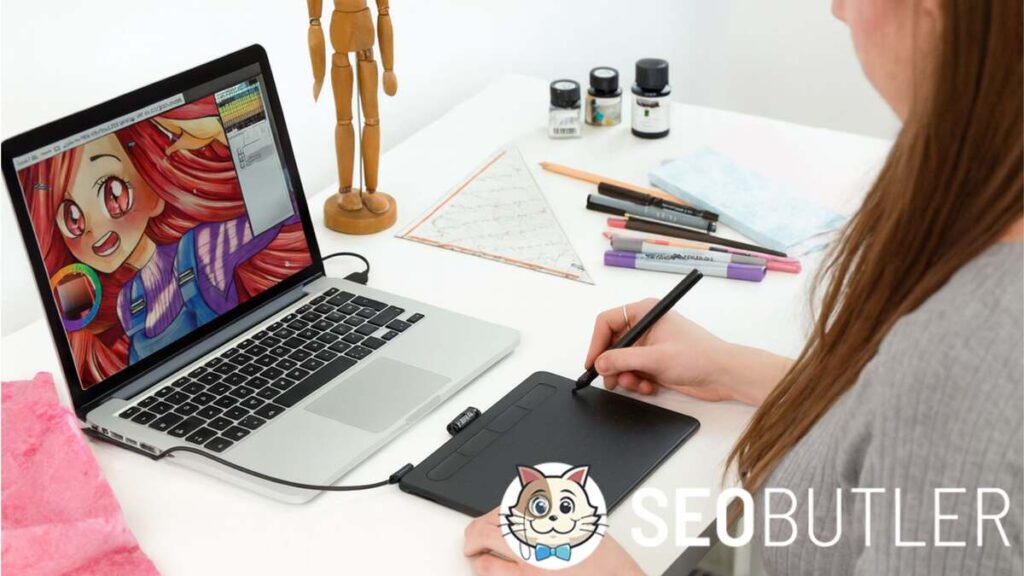 A young woman uses a pen tablet connected to a MacBook Pro, digitally painting a colorful anime-style character. Art supplies, markers, and a wooden mannequin are arranged neatly on the white desk.